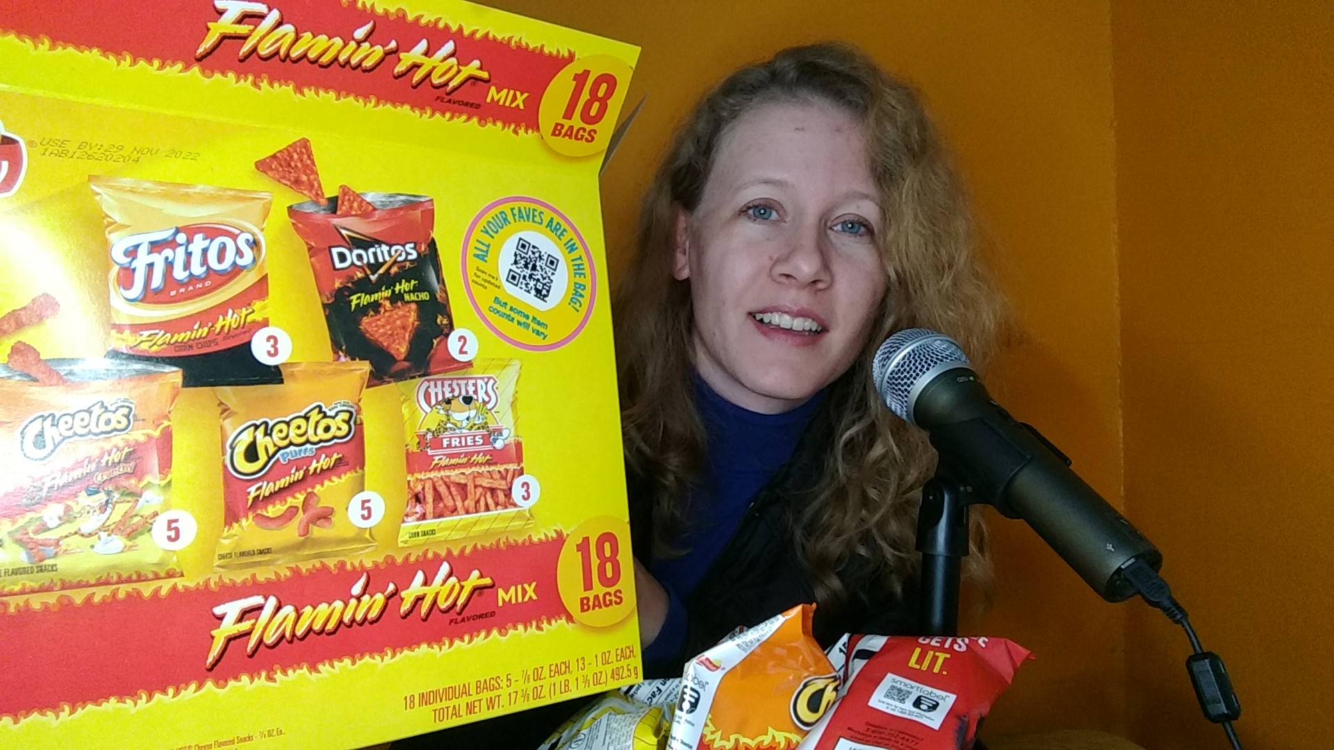 Me, Katie Patton, smiling while holding a box of Flamin' Hot Chips